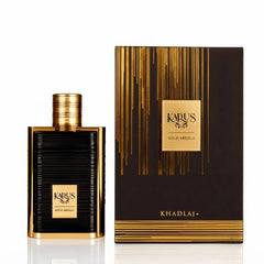 Khapus Gold Absolu perfume bottle next to its black and gold presentation box, featuring gold lettering and vertical gold stripes on a white background.