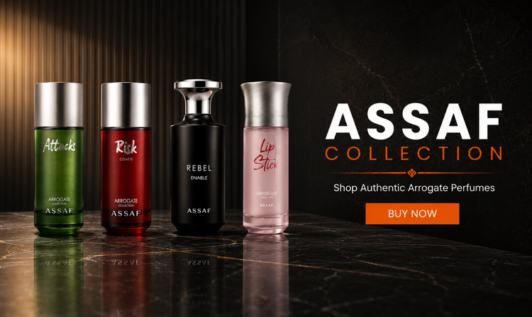 Four ASSAF perfume bottles displayed on a dark marble surface against a black background with warm side lighting. The bottles are green, red, black, and pink, with silver caps.